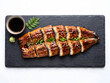© 형석 황 - Unagi kabayaki, Korean grilled eel with soy glaze served on a black slate platter with sauce isolated on white background