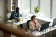 © TrueFrame Collective - High angle view of African American man and Caucasian woman working at desktop computers in office, supporting teamwork, productivity, corporate communication use