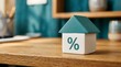 © Wool World - Toy house with percent symbol on wooden desk representing mortgage interest rates