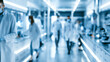 © CStock - A busy laboratory filled with scientists in white coats, engaged in various research tasks under bright lighting.
