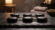 © Muhammad - Smooth black basalt hot massage stones resting wet slate