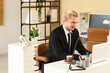 © Pixel-Shot - Young businessman working with laptop at desk in office
