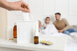 © Pixel-Shot - Ill mother taking tissue from box in bedroom, closeup