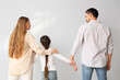 © Pixel-Shot - Little girl with her divorced parents on light background, back view