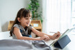 © Kawee - Caucasian young kid learning online class with teacher in cozy house.