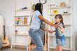 © Kawee - Caucasian young girl and African American nanny dancing in nursery home.