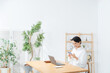 © metamorworks - 部屋でスマホとノートパソコンを使う女性。アプリ、フリーランス、仕事、ライフスタイル、DX