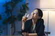 © metamorworks - 暗い部屋でお酒を飲む女性。ビール、ウイスキー、飲み会、居酒屋、バー、スナック、宅飲み