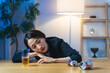 © metamorworks - 暗い部屋で酔い潰れる女性。お酒、ショック、がっかり、落ち込む、やけ酒、酔う、アルコール、居酒屋