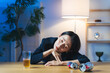 © metamorworks - 暗い部屋で酔い潰れる女性。お酒、ショック、がっかり、落ち込む、やけ酒、酔う、アルコール、居酒屋