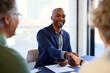 © Rido - African american businessman shaking hands with mature couple