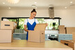 © Home-stock - Smiling woman opening cardboard box in kitchen while unpacking after moving house