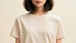 © Punnn - Minimalist Portrait: A young woman with a chic bob haircut and fair skin wears a simple beige t-shirt, exuding understated elegance and natural beauty in a soft, neutral-toned studio setting.