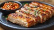 © NURUL - Grilled Pork Belly with Kimchi on Black Plate.