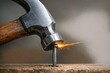 © Fotograf - A hammer striking a nail with sparks flying off