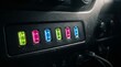 © Wisnu - Row of colorful illuminated auxiliary switches on a vehicle dashboard panel with neon lighting effects