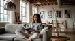 © Владимир Platon - Young woman reading a book on a comfortable sofa in a bright modern loft living room.