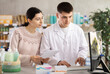 © JackF - Young man pharmacist giving prescription pills to young woman buyer in pharmacy