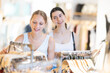 © JackF - Two young women buyers choosing summer dress in clothing store