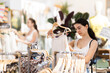 © JackF - Young woman stands near the hangers in the store and chooses a tank top from the new summer collection