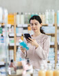 © JackF - Young woman buyer scanning qr code for bottle of mouthwash in pharmacy