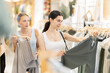 © JackF - Woman chooses green pants against the background of female friend. Two customers buy pants.