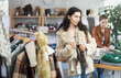 © JackF - Young woman buyer trying on fur coat in clothing store