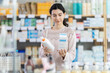 © JackF - Girl in autumn clothes choosing skin cream at the drugstore