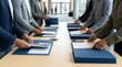 © obak - Hands meticulously organizing business materials into blue folders at a professional event, showcasing preparation and attention to detail