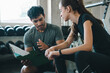 © chokniti - Trainer client gym clipboard consultation fitness exercise coaching session woman man discuss workout plan with focused expression near weight rack in modern health club