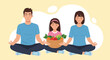 © Silvia - Family meditating together holding a basket of fresh vegetables.