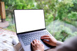 © Farknot Architect - Mockup image of a woman working and typing on laptop computer with blank desktop white screen on the bed at home