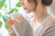 © buritora - A stylish Asian woman enjoying her morning coffee, hot drink, and soup in the living room.