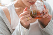 © buritora - A woman's hands as she drinks black tea or herbal tea during teatime.