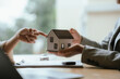 © Kieng - Real estate agent explaining a home purchase agreement with house and car models, representing property investment, financing, and ownership.