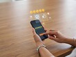 © mahfuzakhatun - Hands holding smartphone and interacting with a five-star rating and other virtual icons.