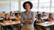 © Curioso.Photography - Smiling teacher standing confidently in a bright classroom with diverse elementary students engaged in learning.