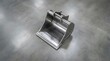 © MdAtiq - Heavy duty steel excavator bucket attachment for industrial construction machinery and earthmoving equipment on grey concrete background.