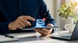 © Anhidrit'12 - Businessman holding tablet with glowing email notification icon popping up representing new message and digital communication