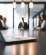 © Selvam - Contemporary boardroom gathering featuring professionals with their faces partially visible, engaged in a strategy discussion at a table with a laptop