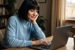 © Aleksei Solovev - Woman working remotely on a laptop in a cozy setting, embodying digital nomad lifestyle and focus.