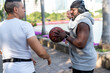 © Rawpixel.com - Black man with headphones holding a basketball talking to a white man