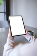 © Farknot Architect - Vertical mockup image of a woman holding digital tablet with blank white desktop screen in cafe