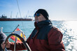 © Nazareno - Man driving sailboat steering wheel enjoying ocean voyage