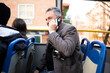 © Nazareno - Man talking on smartphone aboard public bus during commute