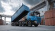 © Artittaya - Blue Heavy-Duty Commercial Truck Unloading Cargo Container In Industrial Warehouse Environment