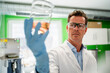 © Westend61 - Scientist wearing eyeglasses examining measuring beaker at laboratory