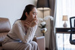 © crizzystudio - Woman coughing covering mouth with hand at home