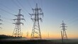 © Olesya - High voltage power transmission lines at sunrise with morning fog, electricity pylons across rural landscape, energy infrastructure, scenic industrial background