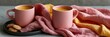 © Iryna - Two pink mugs with golden turmeric latte and cookies on pink and yellow linen for cozy breakfast background and banner design